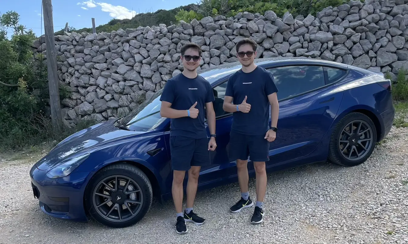 Die Tinz Twins vor ihren Tesla Model 3