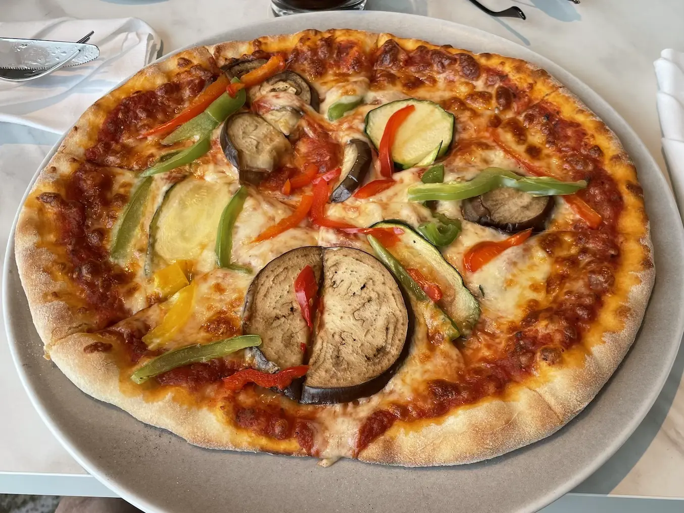 Pizza mit Tomatensauce, Mozzarella, Aubergine, Zucchini und Paprika