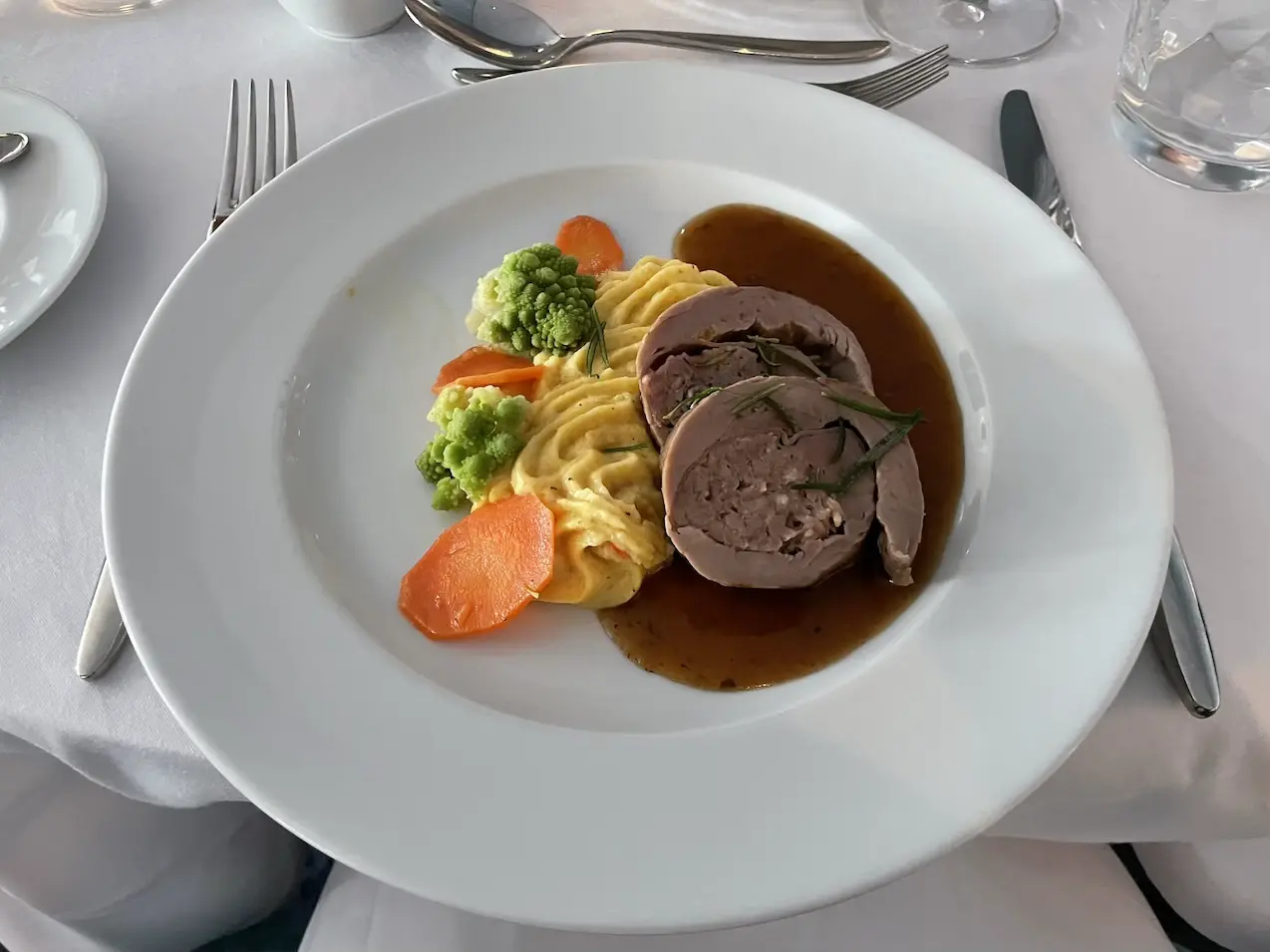 Geschmorter Kalbsrollbraten Saltimbocca an Thymianglace mit Karottengemüse und Limetten-Polenta
