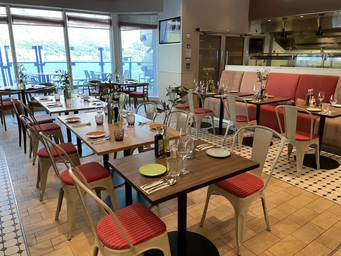 Sitzbereich mit Stühlen in der Osteria auf der Mein Schiff 6