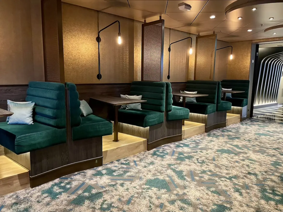 Grüne, gemütliche Sitzbänke in der Schau Bar auf der Mein Schiff 6