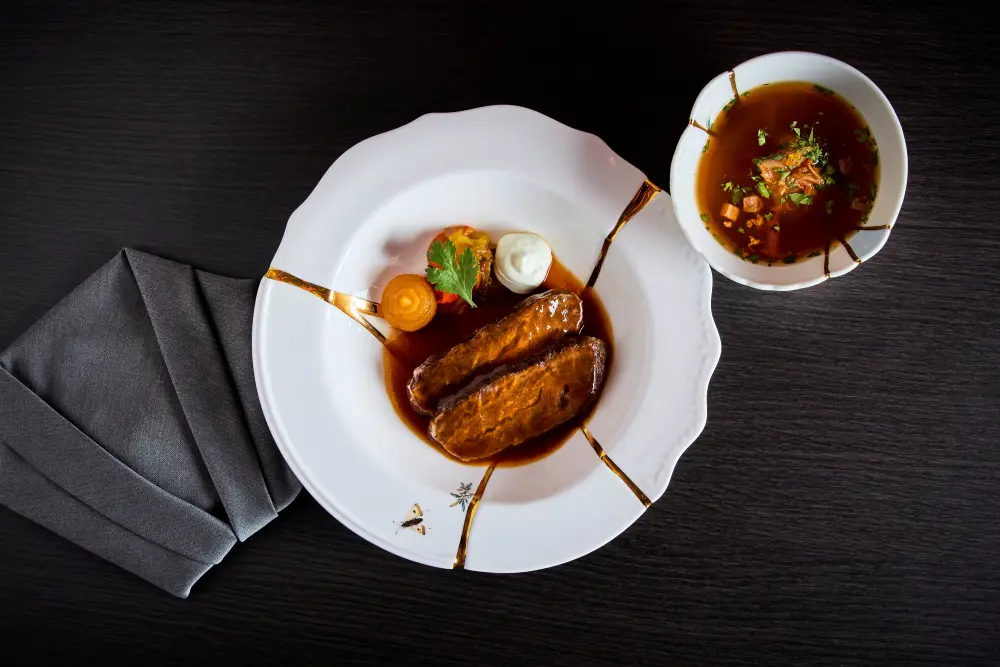 Japanisches Fleischgericht mit Sauce und bunter Dekoration, serviert auf weißem Porzellanteller.