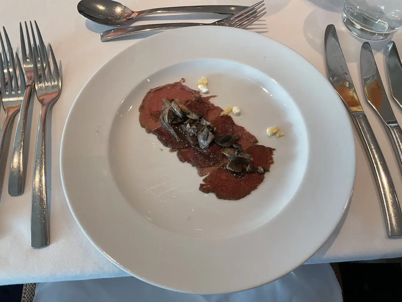 Hirschcarpaccio, mit Thymian mariniert, dazu gebratene Pilze und Parmesan